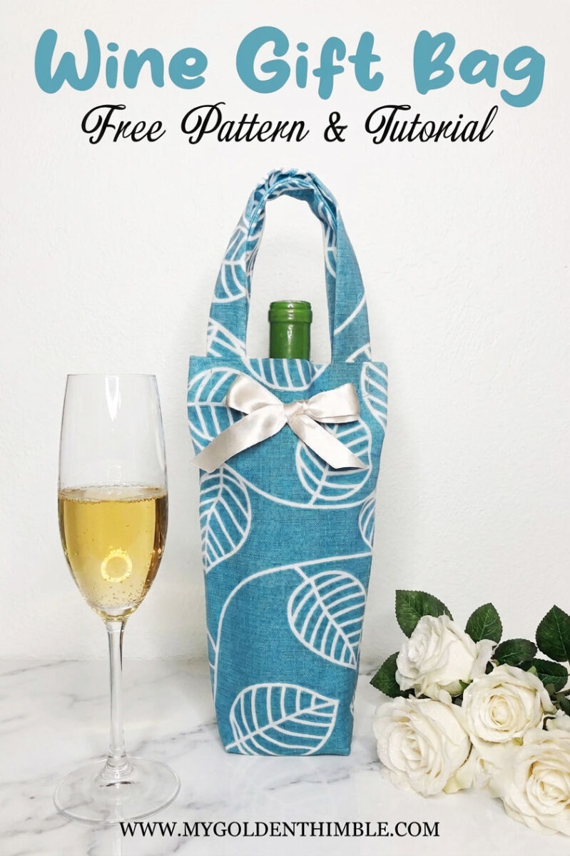 blue wine tote bag made with a free tutorial on a marble table with roses on one side and a wine cup on the other
