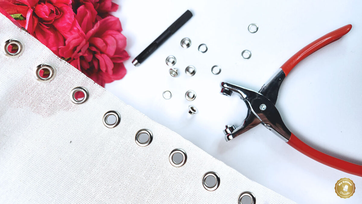 close up fabric with grommets and pliers