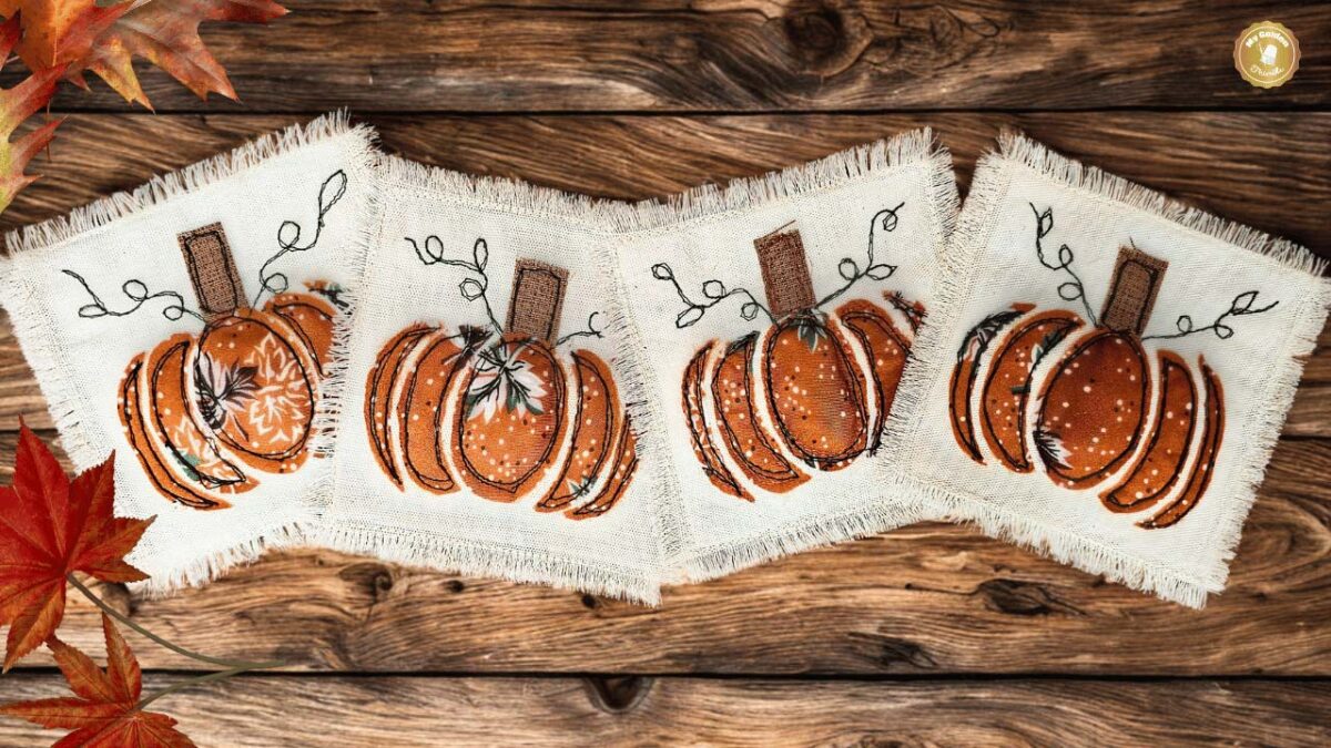 Handmade pumpkin-shaped coaster in orange fabric with appliqué stem and leaves.