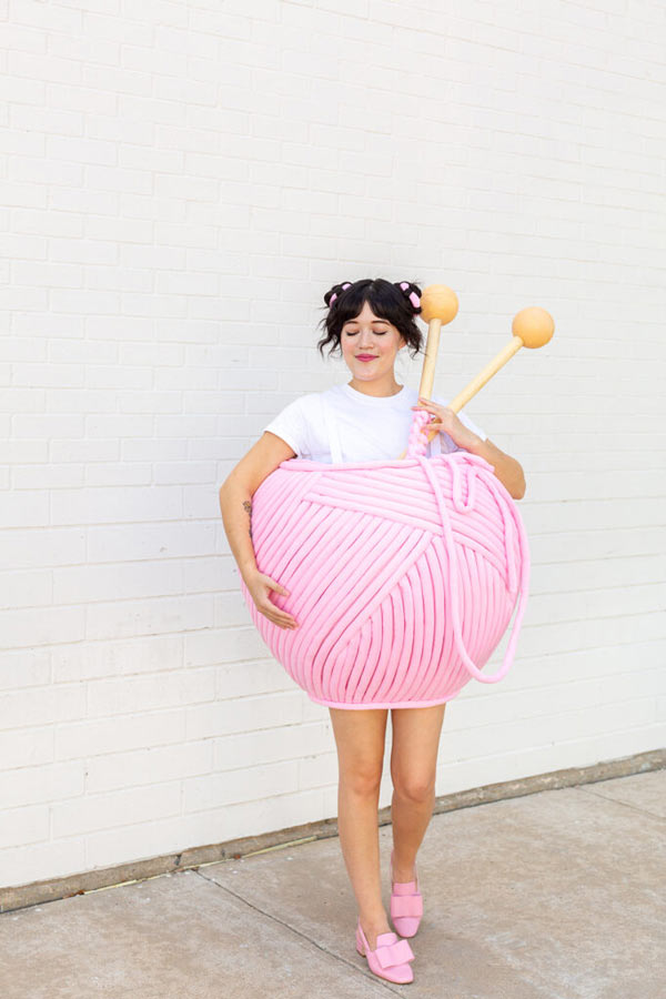 young woman dressed in a yarn ball costume pink