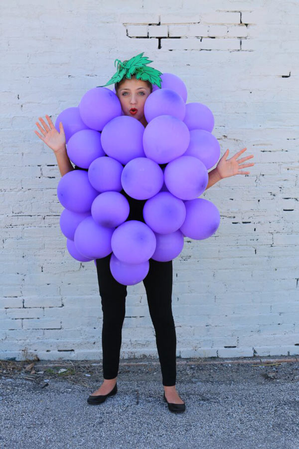 woman dressed as a grape using purple baloons around her body