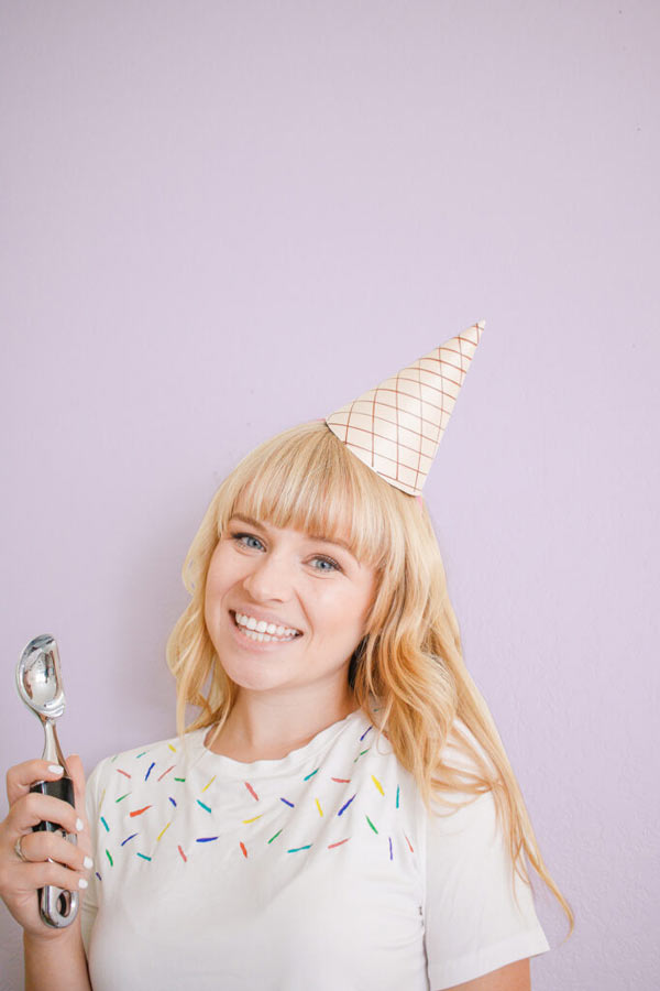 girl with a white t-shirt with colors and a cone on her head