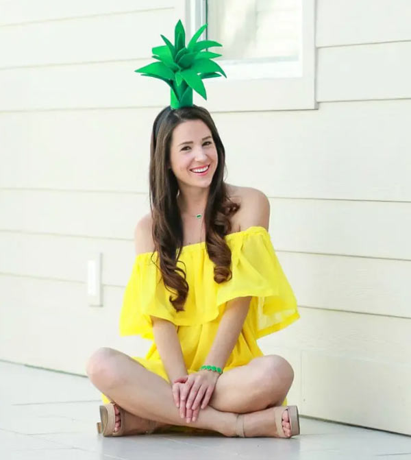 girl with a yellow dress and a paper hat made with green paper