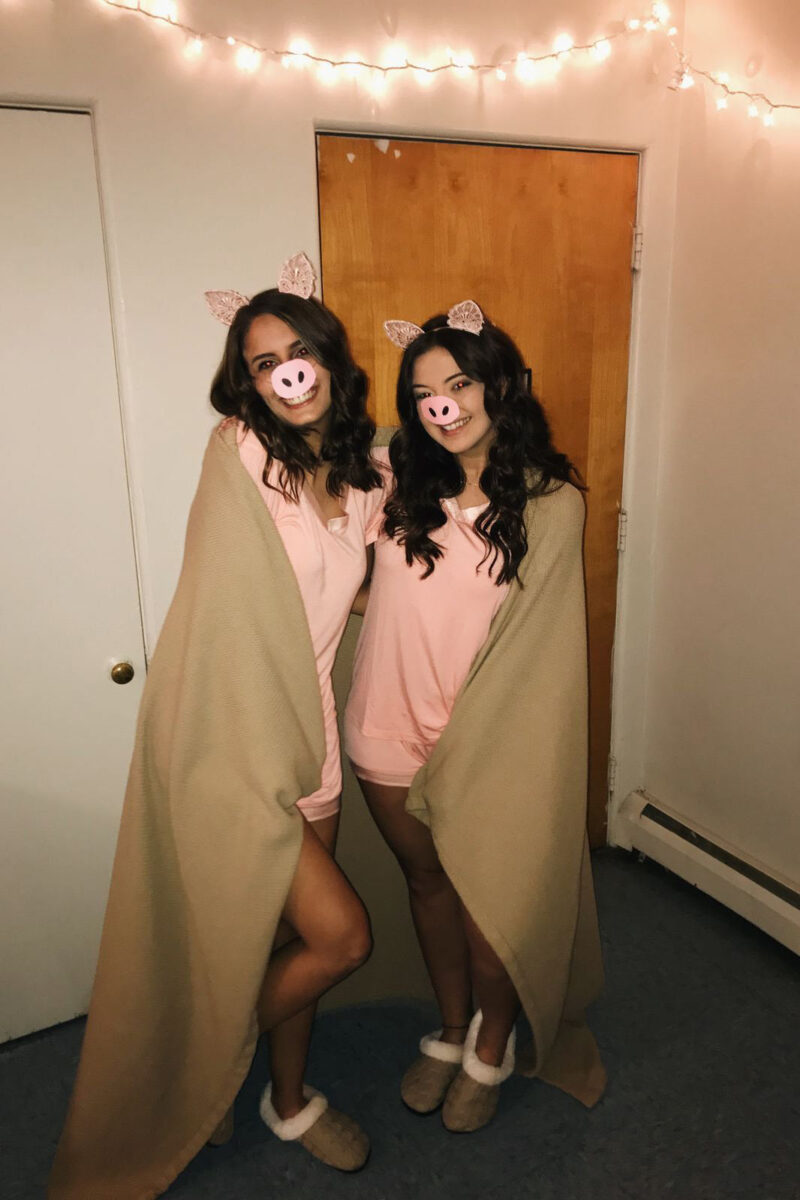 two girls with pink t-shirts covered in a blanket
