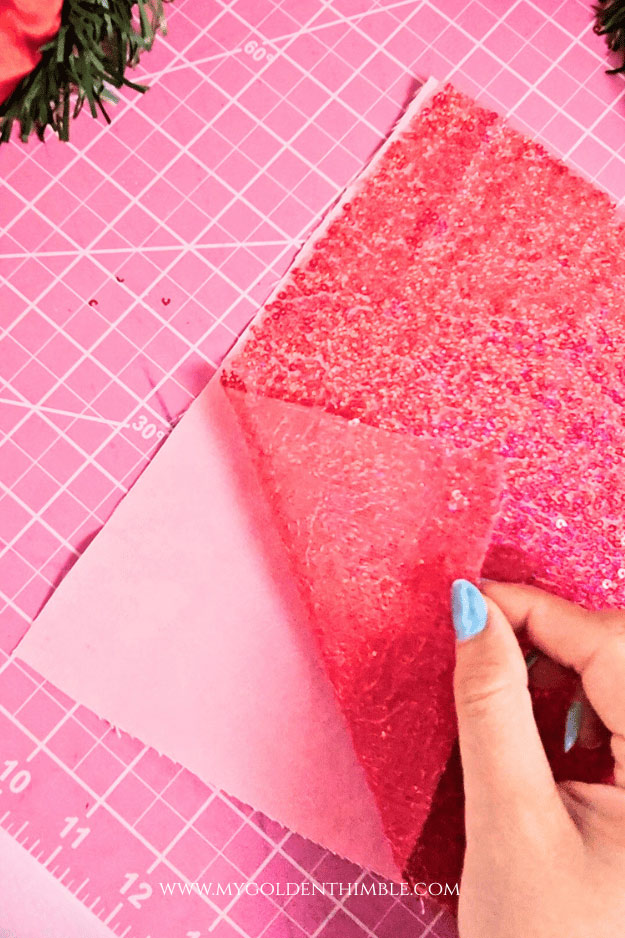 Hot pink sequin fabric placed on top of sturdy canvas fabric