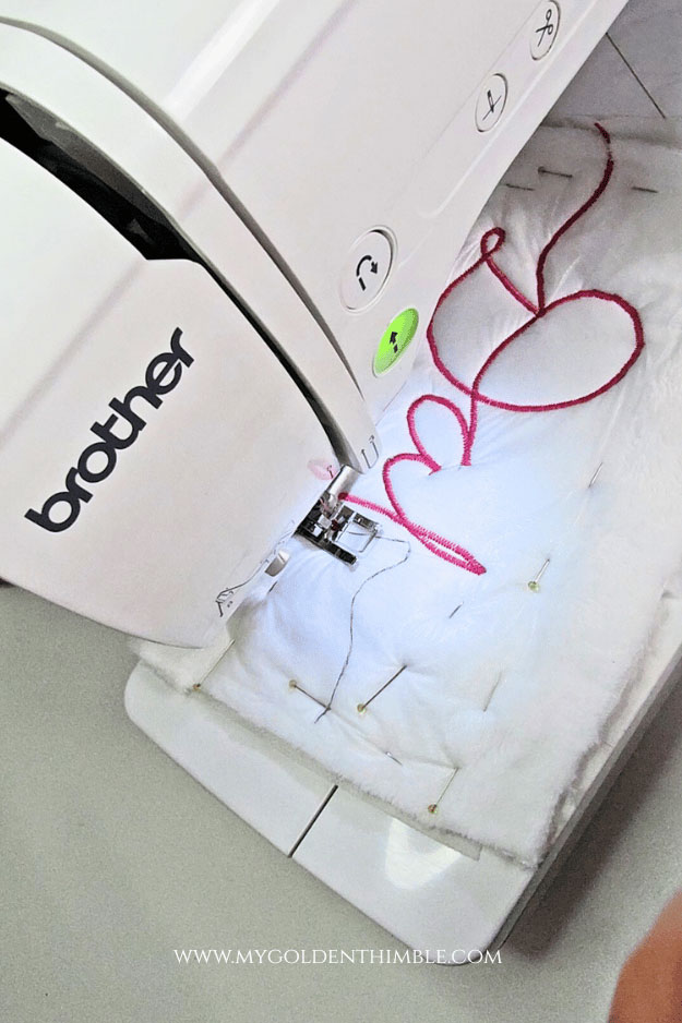 Embroidering the name on the stocking cuff using a regular presser foot and narrow zigzag stitch.