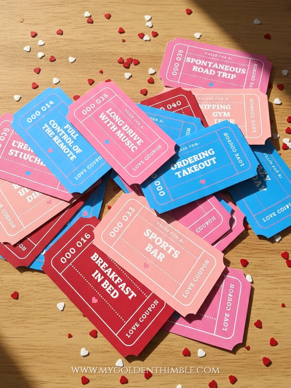 Scattered printable Valentine’s Day coupons in pink, red, and blue with romantic activities on a wooden surface.
