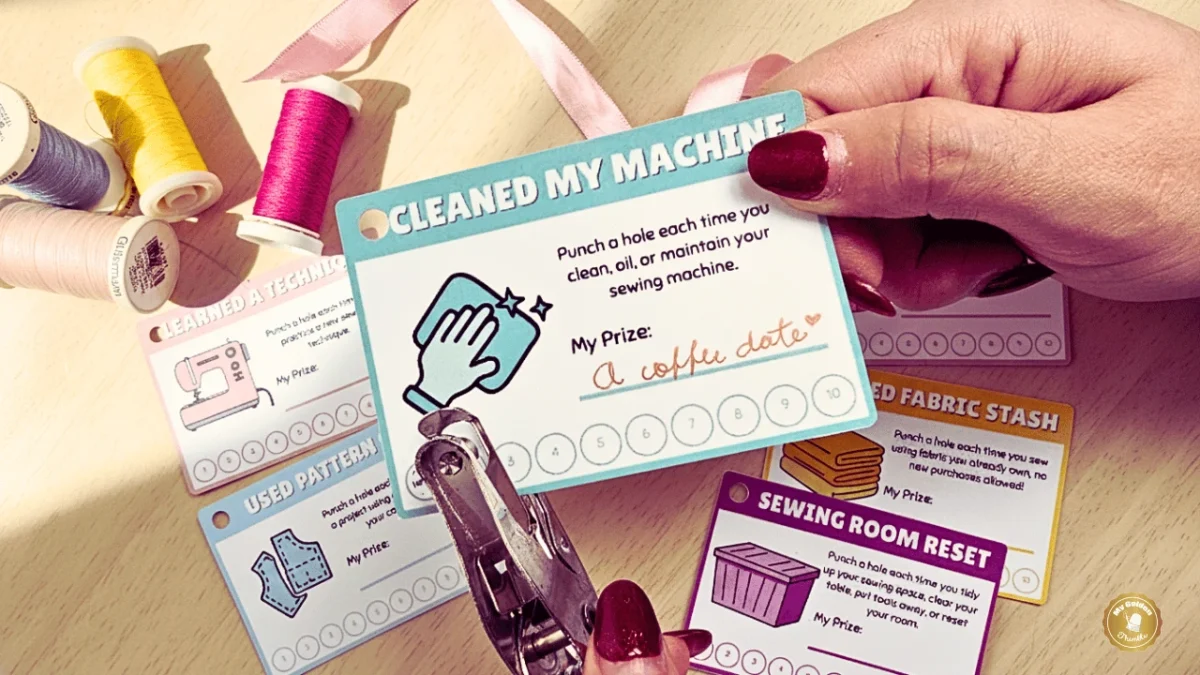 Motivational sewing punch cards resting on a craft table with threads placed around for decoration.