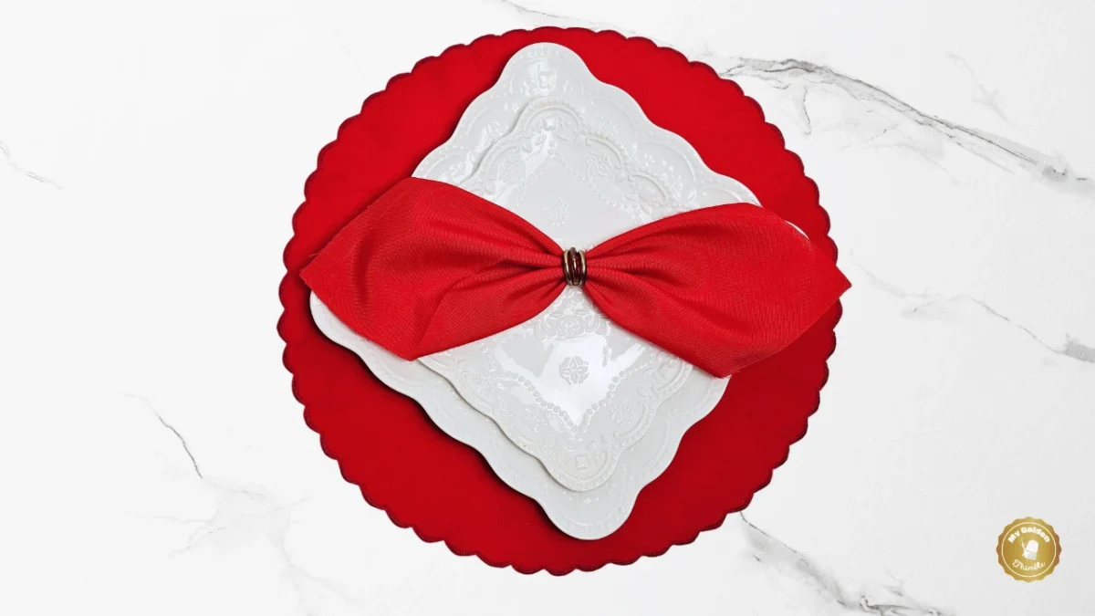 Close-up of a DIY round scalloped placemat with decorative stitch edging, paired with a white plate and red napkin on a marble background.
