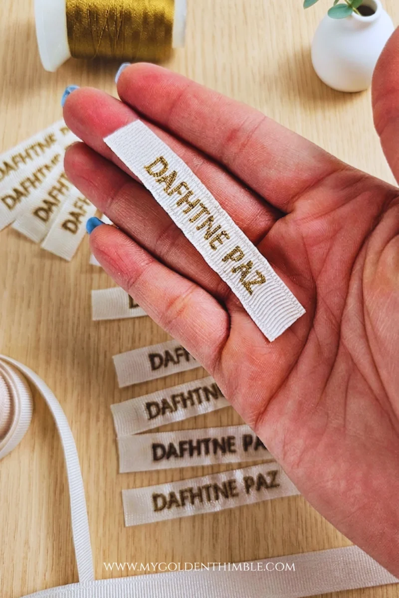 Close-up of DIY clothing labels stitched on ribbon using an embroidery sewing machine