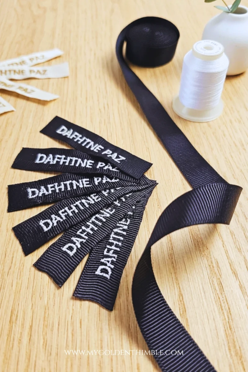 Embroidery machine stitching personalized fabric labels on ribbed ribbon