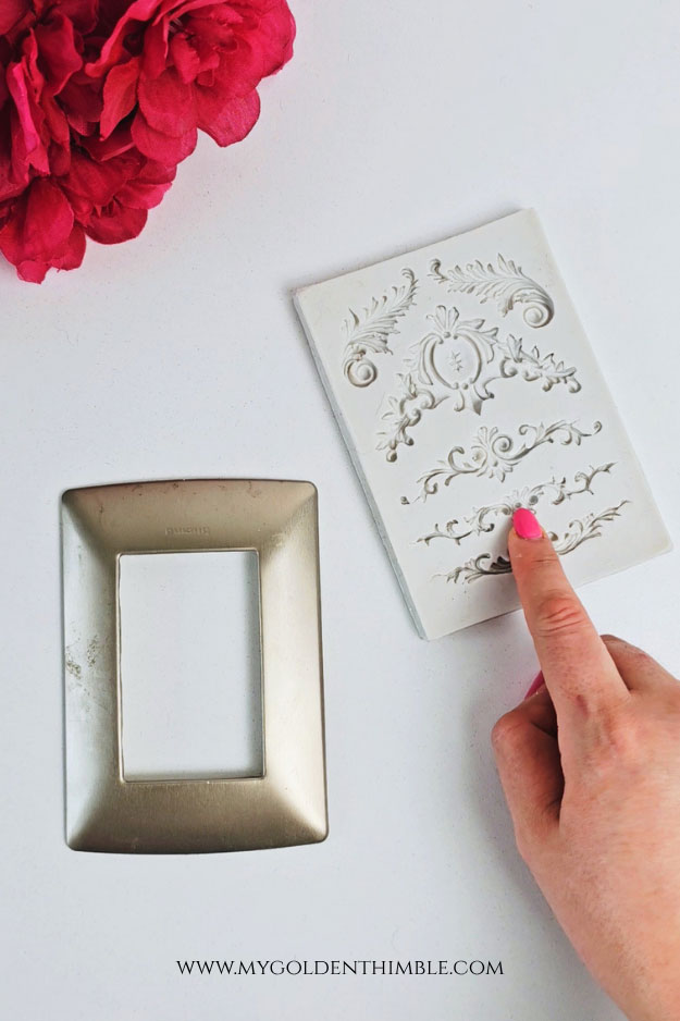 Applying hot glue into silicone mold to create decorative details