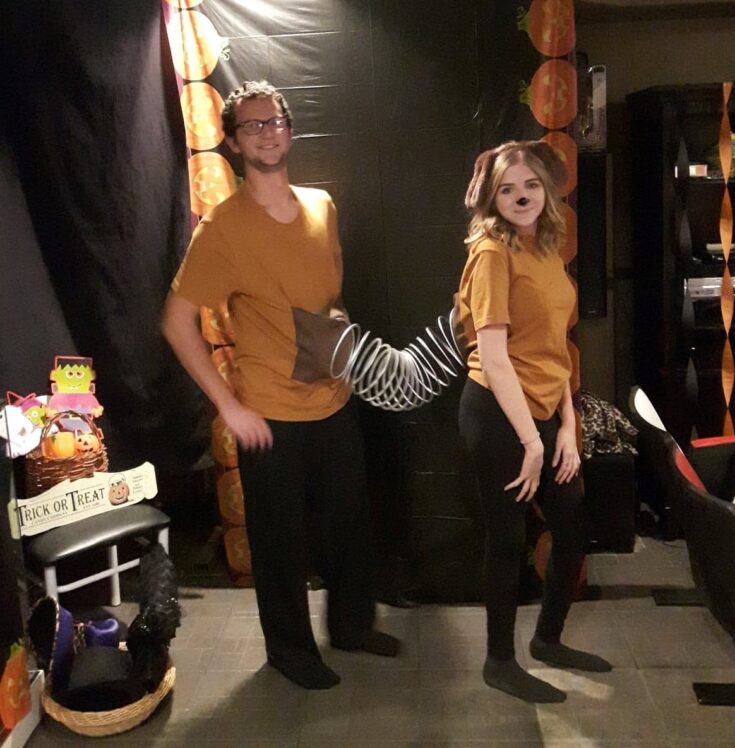 two friends dressed as a dog join with a spiral toy in the middle