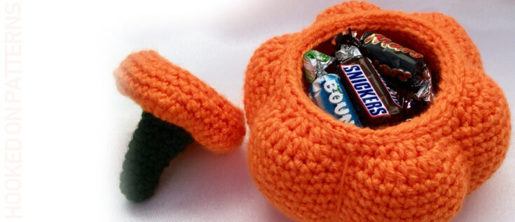 Orange crochet pumpkin-shaped container filled with candy