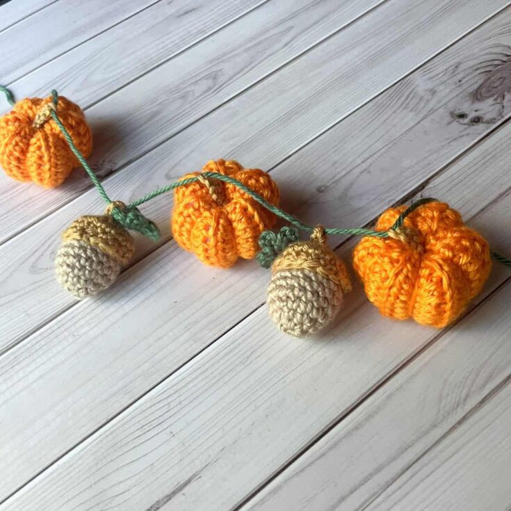 Crochet garland made with small orange, yellow, and brown pumpkins