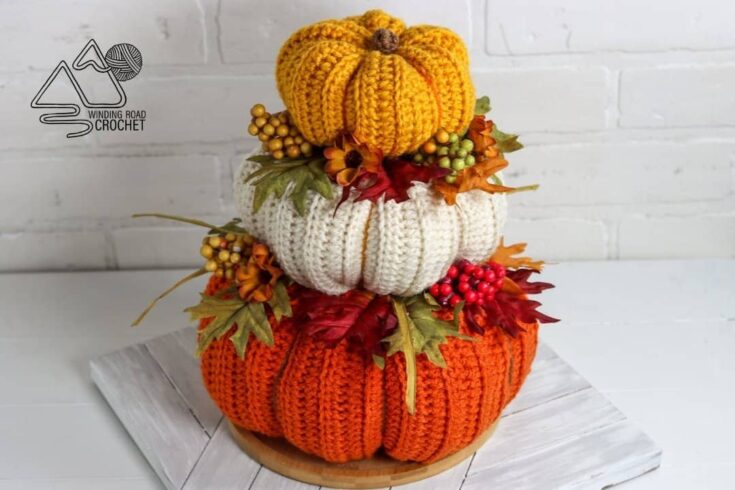 Fall crochet centerpiece featuring stacked pumpkins in orange, cream, and yellow