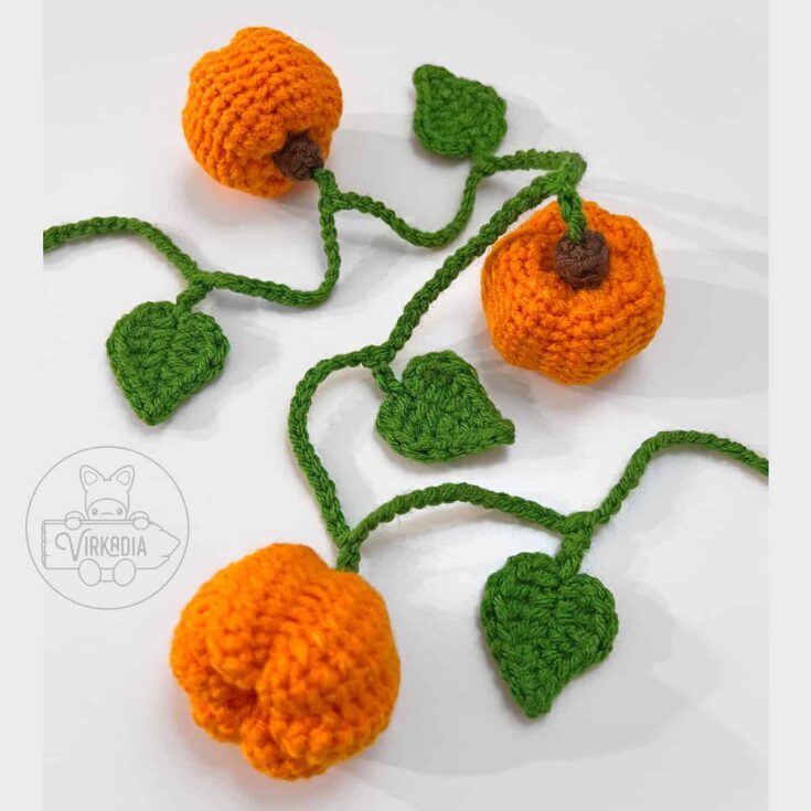 Mini crochet pumpkin garland with orange pumpkins and green leaves