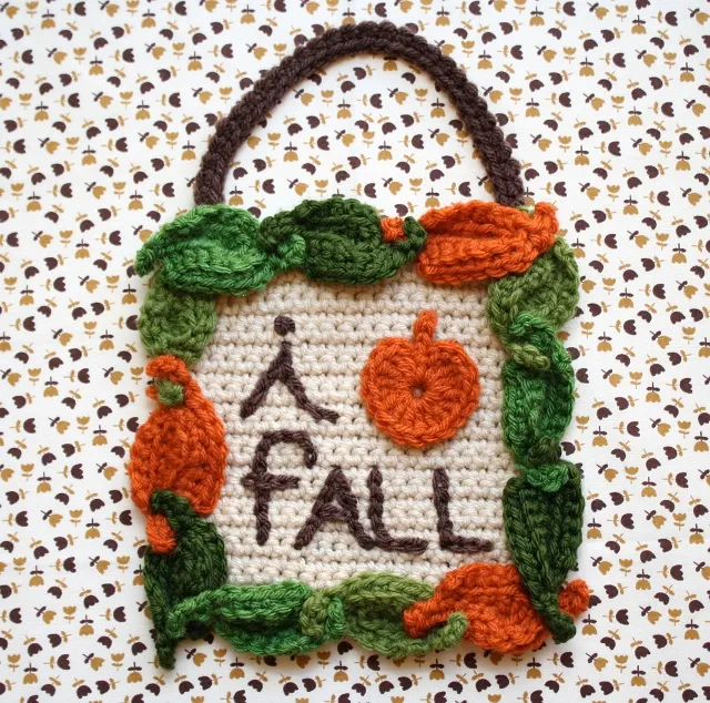 Crochet fall sign decorated with pumpkins, leaves, and autumn motifs