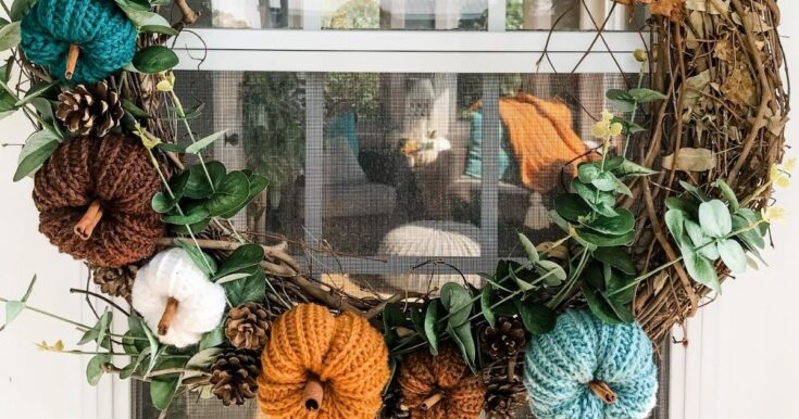 Fall wreath decorated with crochet pumpkins and autumn foliage