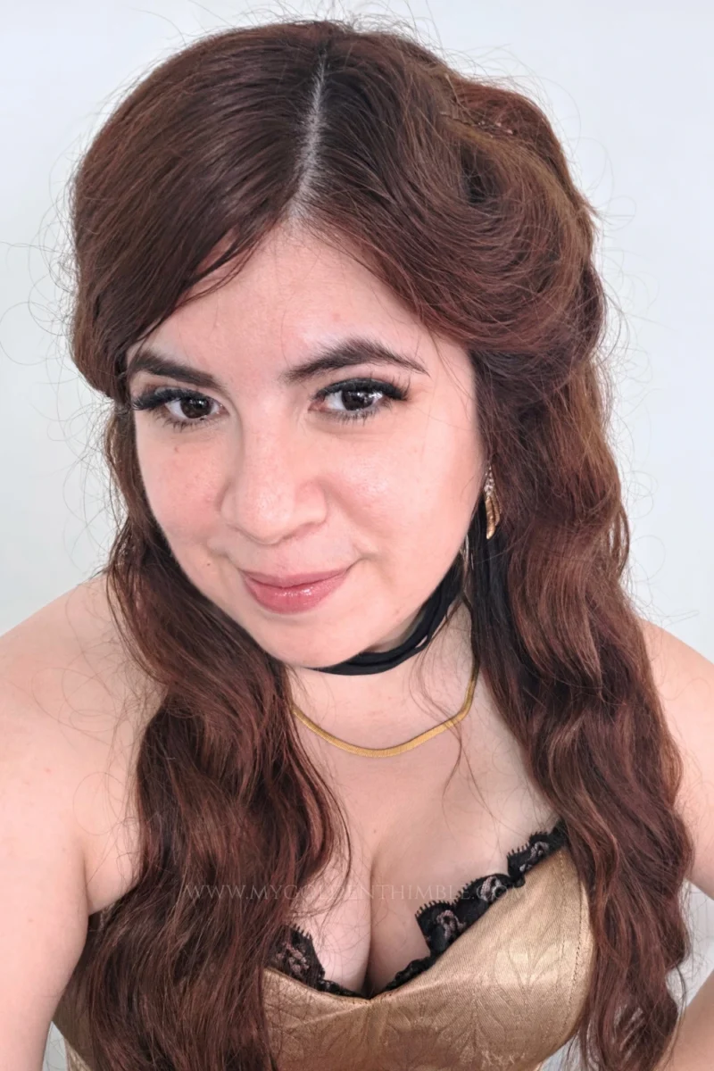 Close-up portrait of a woman showcasing her vintage-inspired hair and makeup for a burlesque costume.