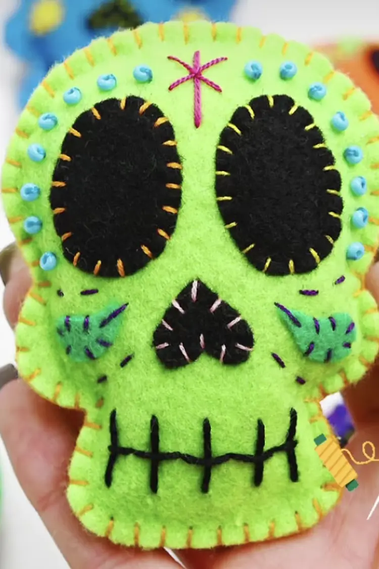 Lime green felt sugar skull ornament with black felt details and hand-stitched borders.