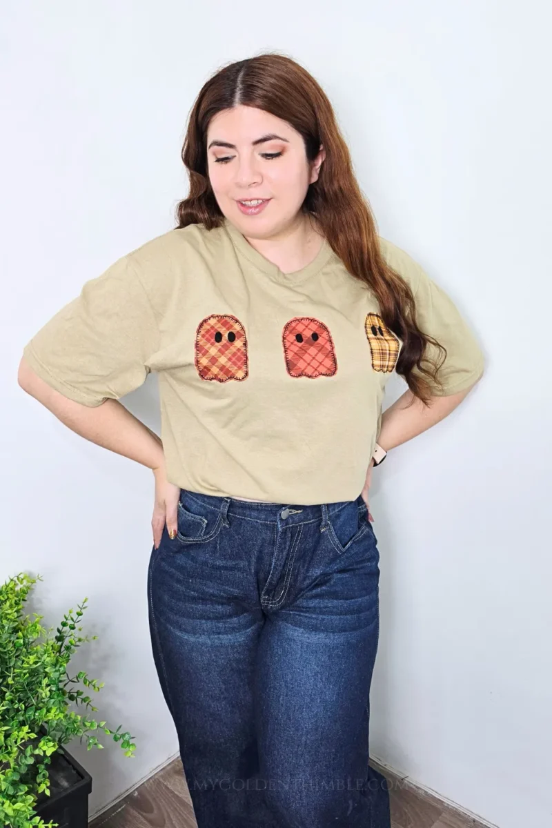 Full-length view of a smiling woman standing and modeling the beige DIY ghost applique t-shirt.
